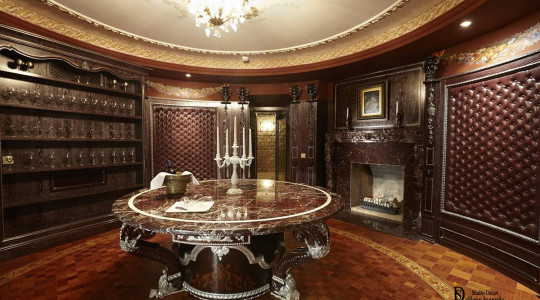 Tasting room with fireplace, marble table, wine glass shelves Tasting room with marble table