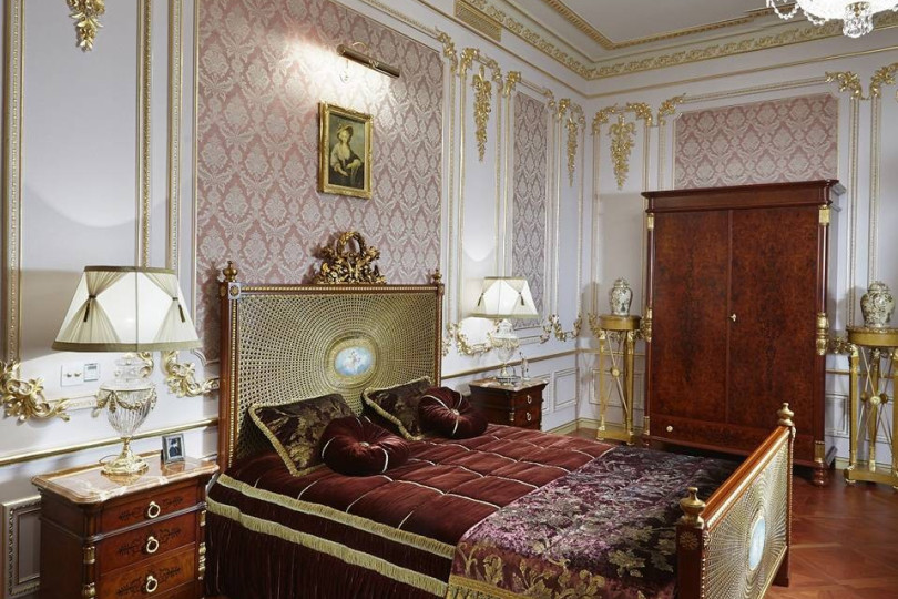 Спальня в неоклассическом стиле с золоченной лепниной, вычурными элементами  декора и интерьера Спальня в неоклассическом стиле цвета бордо