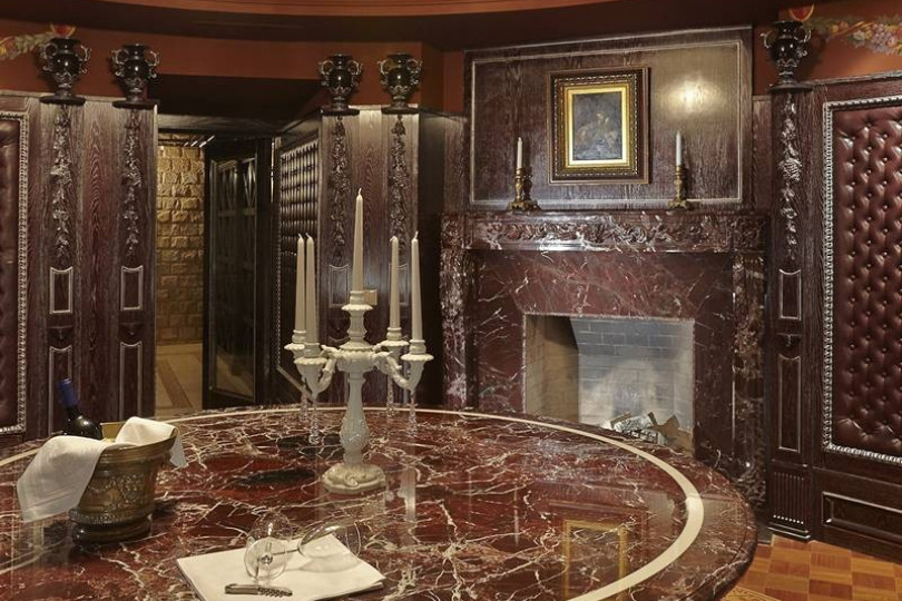 Дегустационная комната с камином, мраморным столом, наборным паркетом и  декоративными панелями Дегустационная комната с камином