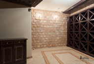 The wine cellar is equipped with special shelves for storing fine drinks in beige and brown tones Wine cellar with shelves and exquisite design