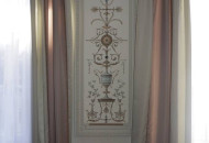 The walls are decorated with painting framed by plaster stucco molding, with which the color of the curtains is in harmony Living room with decorative stove with tiles