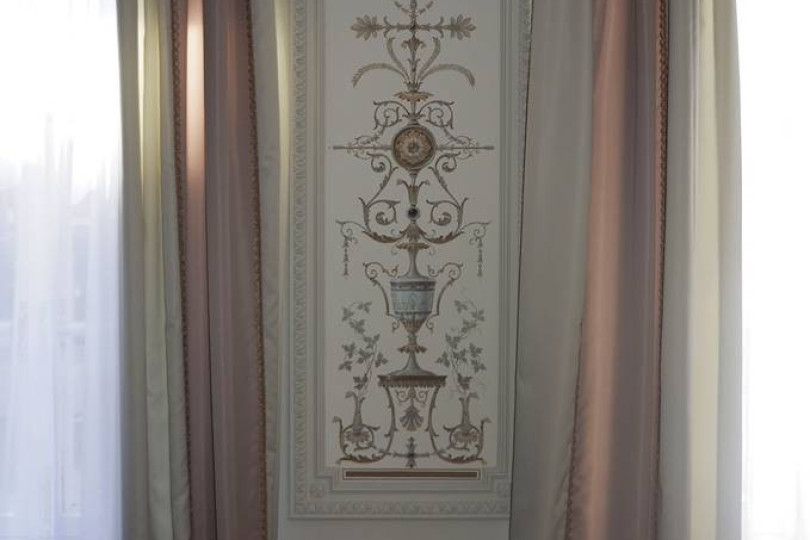 Стены украшены росписью в обрамлении гипсовой лепнины, с которой гармонирует  цвет портьер Интерьер гостиной с декоративной росписью