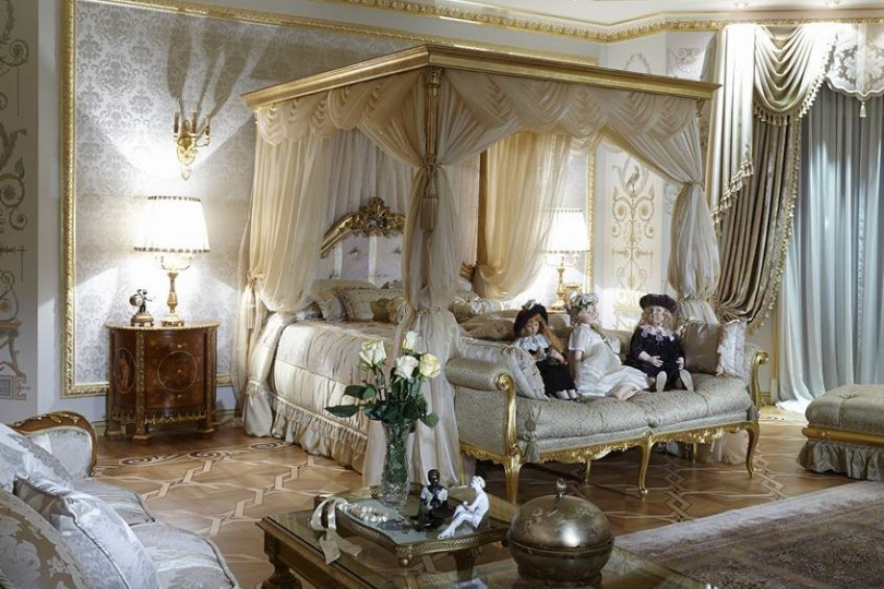 Bed and canopy in the bedroom, sofa and coffee table with gilding create a sophisticated environment Bedroom with four poster bed