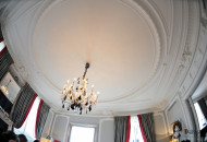 A chic chandelier framed by stucco molding emphasizes the flawless lines of the interior, and the curtains give it palace grandeur Ceiling molding emphasized the nobility of the interior