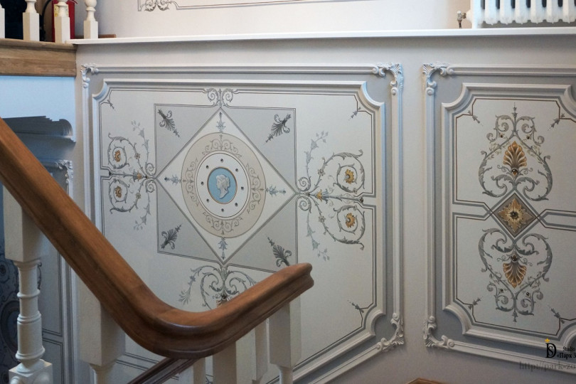 Изящная лепнина делит стены на поля, подчеркивает динамику движения. Она привлекательна, но при этом не яркая, изысканная, а не вычурная Роспись стен парадной лестницы