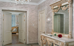 A small hall in light colors is decorated with marble, plaster stucco molding, skillfully carved and gilded on wood Classic light hall