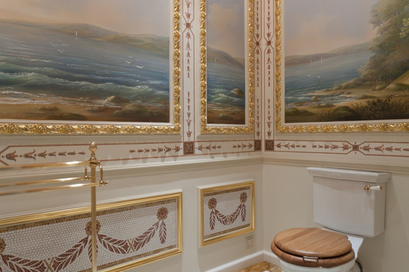 Perspective painting, gilded stucco moldings complement modern plumbing equipment Bathroom with bidet, painted and gilded stucco