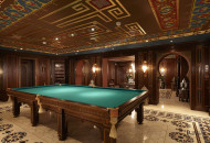 The low-rise billiard room is decorated in Moroccan style. Oriental motives can be seen in the painting, arched openings, decorative elements and lamps Billiard room decorated in Moroccan style