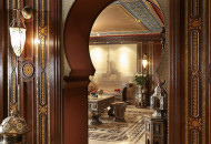 An intricately carved horseshoe arch connects the billiard room with the living room. Billiard room decorated in Moroccan style