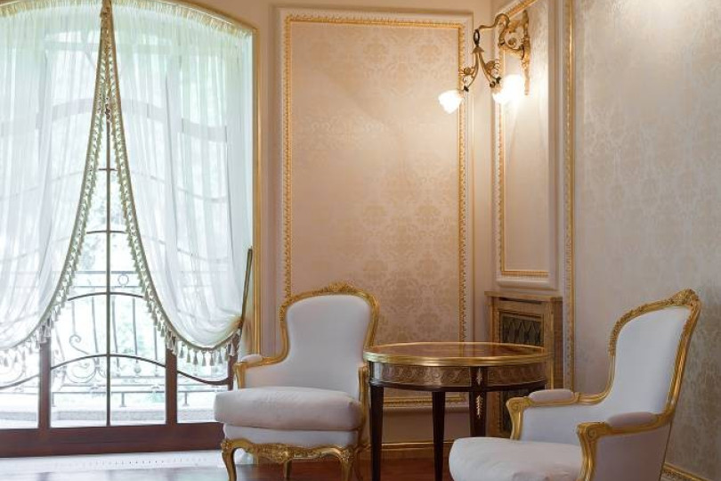 Роспись потолка, позолота лепнины, мебель классических форм, легкие светильники, полупрозрачные шторы дарят гармонию и легкость Зона входа на террасу, декорированная паркетом и золоченой лепниной