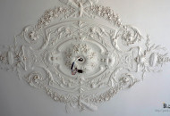 Plaster molding rosette in a classic interior installation of a plaster stucco socket