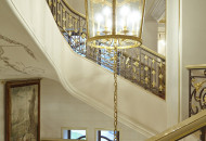To the light basic tone of the staircase, gilding of details, alfrey painting and a large stylized painting are subtly added Staircase in a country mansion with painting and gilding
