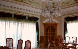 The large, bright dining room is decorated in light colors typical of the Mediterranean, which are complemented by exquisite stucco molding, painting and a rich chandelier Mediterranean style dining room