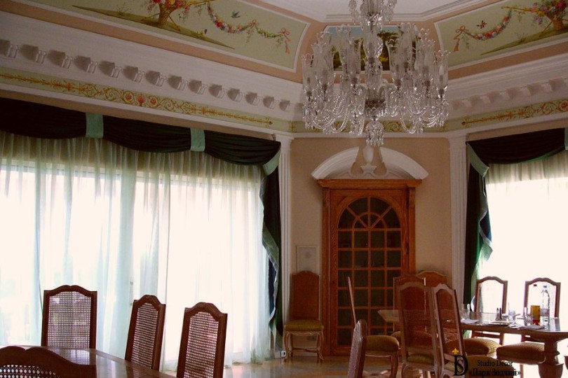The large, bright dining room is decorated in light colors typical of the Mediterranean, which are complemented by exquisite stucco molding, painting and a rich chandelier Mediterranean style dining room