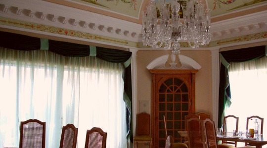 The large, bright dining room is decorated in light colors typical of the Mediterranean, which are complemented by exquisite stucco molding, painting and a rich chandelier Mediterranean style dining room