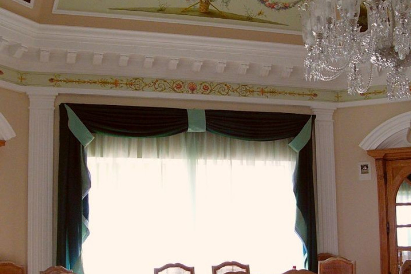 Light walls, snow-white ceiling of the dining room are complemented by alfrey, panoramic painting and stucco decorative elements Light dining room decorated in Mediterranean style